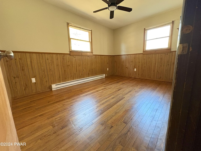 unfurnished room featuring ceiling fan, a baseboard radiator, and wood-type flooring