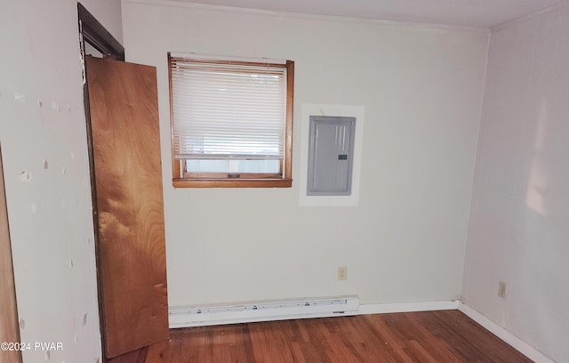 spare room with electric panel, dark hardwood / wood-style floors, and a baseboard heating unit