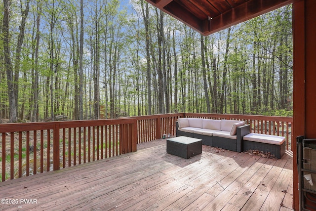 wooden terrace with an outdoor hangout area and a forest view