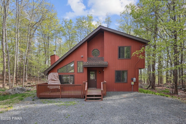 rustic home with a wooden deck and a chimney