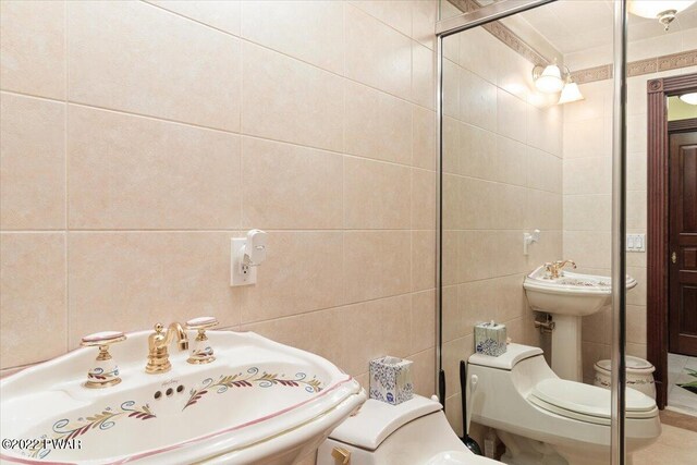 bathroom with toilet, tile walls, and sink