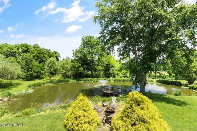 surrounding community with a lawn and a water view