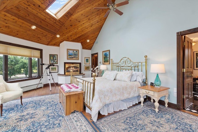 bedroom with a skylight, ceiling fan, high vaulted ceiling, a baseboard heating unit, and hardwood / wood-style flooring