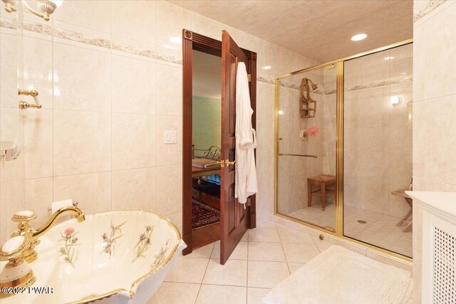 bathroom featuring tile patterned flooring, tile walls, and independent shower and bath