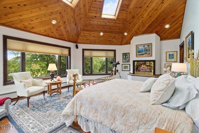 bedroom featuring a skylight, baseboard heating, wood-type flooring, high vaulted ceiling, and wooden ceiling