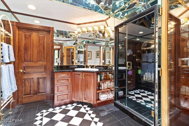 bathroom with tile patterned floors, vanity, a shower with shower door, and ornamental molding