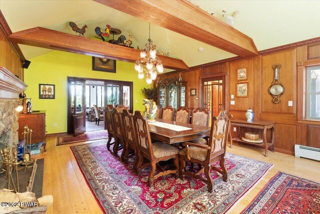 dining room with wood walls, an inviting chandelier, lofted ceiling with beams, a baseboard radiator, and light hardwood / wood-style floors