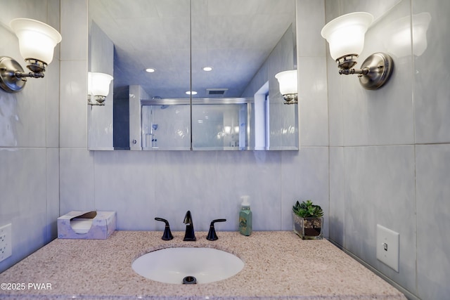 bathroom featuring vanity, a shower stall, recessed lighting, and visible vents