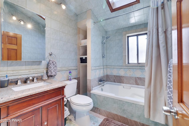 full bathroom featuring tile walls, tile patterned flooring, vanity, toilet, and tiled shower / bath combo