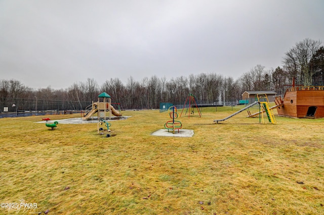 community jungle gym featuring a lawn, an outbuilding, fence, and a storage shed