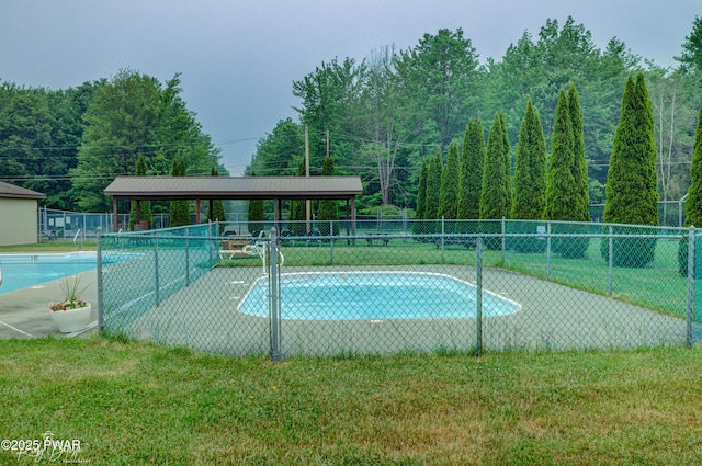view of swimming pool featuring fence and a yard