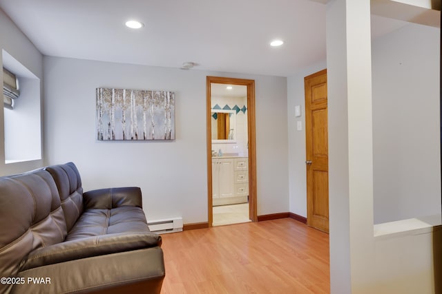 living room featuring recessed lighting, baseboards, baseboard heating, and light wood-style flooring