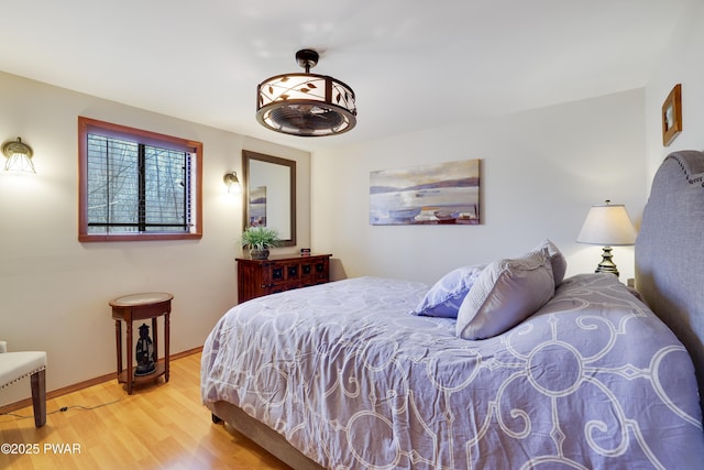 bedroom with baseboards and wood finished floors