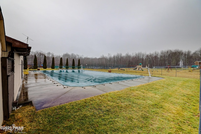 community pool featuring a yard, a patio, fence, and playground community