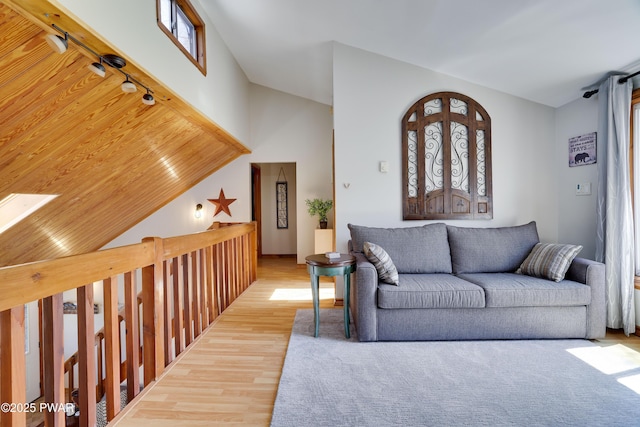 living area with vaulted ceiling and wood finished floors