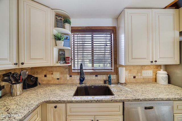 kitchen with open shelves, dishwasher, cream cabinetry, a sink, and backsplash