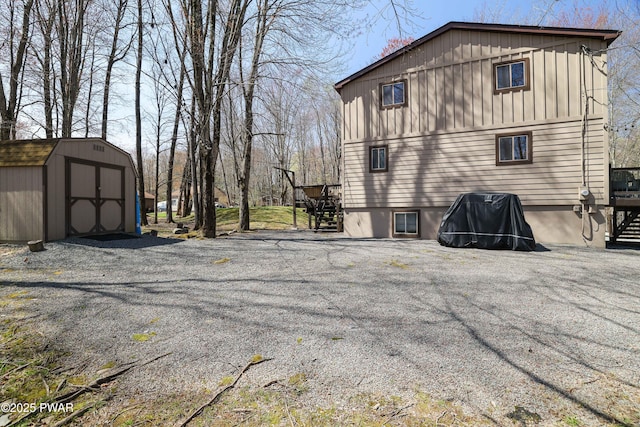 back of property with an outbuilding, stairs, and a shed