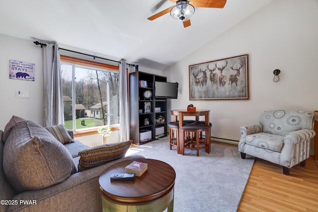 living room featuring a ceiling fan, a baseboard heating unit, wood finished floors, and vaulted ceiling