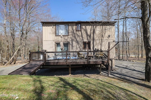 back of property featuring a lawn and a wooden deck