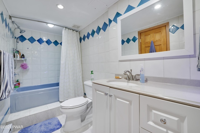 full bath with vanity, toilet, shower / bath combo with shower curtain, tile walls, and visible vents