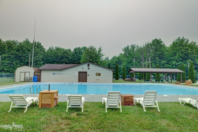 pool with a yard, an outbuilding, and a storage unit