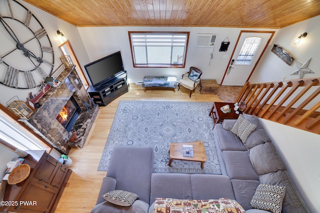 living area featuring wooden ceiling, a wall mounted AC, and light wood finished floors
