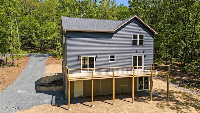 128 Copper Mountain Dr, Tafton, PA 18464 - back of property featuring a wooden deck, a shingled roof, and a wooded view