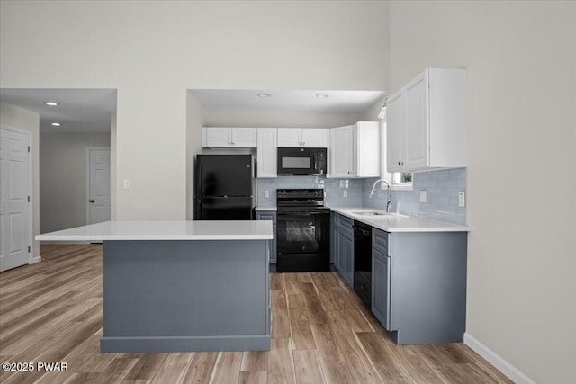 128 Copper Mountain Dr, Tafton, PA 18464 - kitchen featuring black appliances, tasteful backsplash, light wood finished floors, white cabinets, and light countertops
