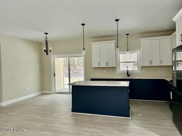 kitchen with decorative light fixtures, white cabinets, and a kitchen island