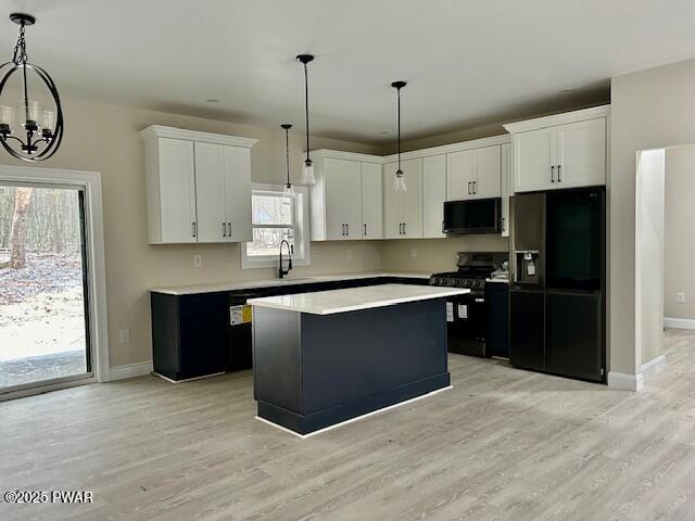 kitchen with a notable chandelier, pendant lighting, black appliances, a kitchen island, and white cabinetry