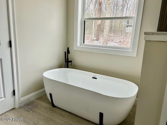 bathroom featuring a bath and hardwood / wood-style flooring