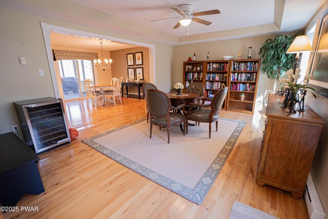92 Thornwood Ter, Lake Ariel, PA 18436 - dining area featuring light wood finished floors, wine cooler, baseboard heating, ceiling fan with notable chandelier, and a tray ceiling