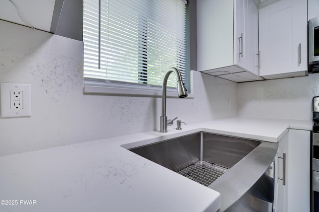 146 Country Club Dr, Thornhurst, PA 18424 - kitchen with white cabinetry, light countertops, and stainless steel microwave