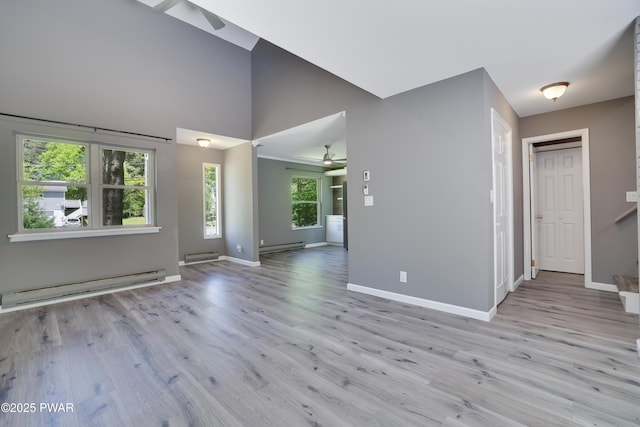146 Country Club Dr, Thornhurst, PA 18424 - unfurnished living room with a baseboard radiator, ceiling fan, light wood-style flooring, high vaulted ceiling, and baseboard heating