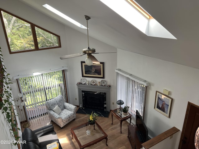 living room with ceiling fan, a fireplace, high vaulted ceiling, and wood-type flooring