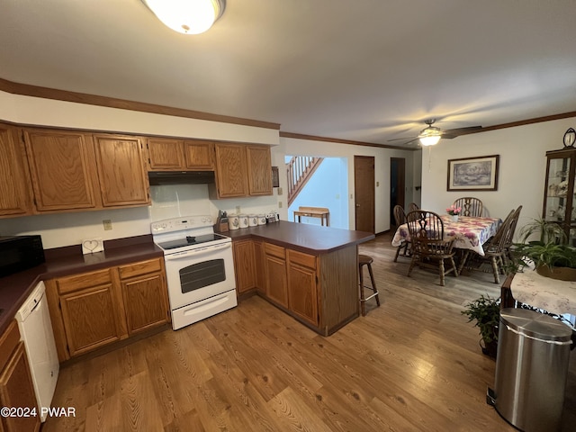 kitchen with kitchen peninsula, hardwood / wood-style floors, white appliances, and ceiling fan