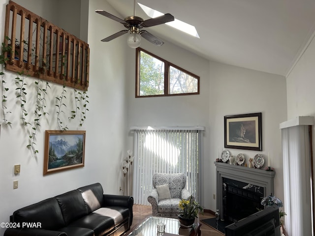 living room with a skylight, ceiling fan, and high vaulted ceiling