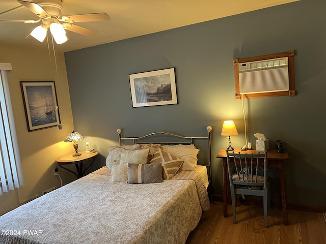 bedroom with hardwood / wood-style floors, a wall unit AC, and ceiling fan