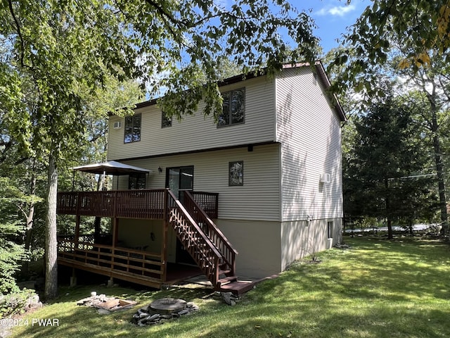 rear view of house with a lawn and a wooden deck