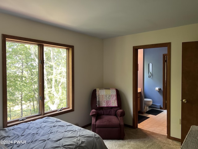 carpeted bedroom featuring connected bathroom and a baseboard heating unit