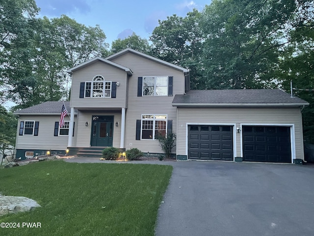 view of front of property with a front yard and a garage