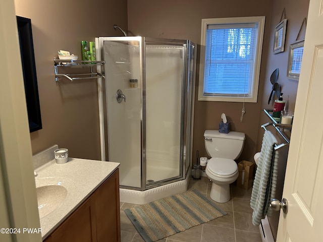 bathroom featuring toilet, vanity, tile patterned floors, and walk in shower