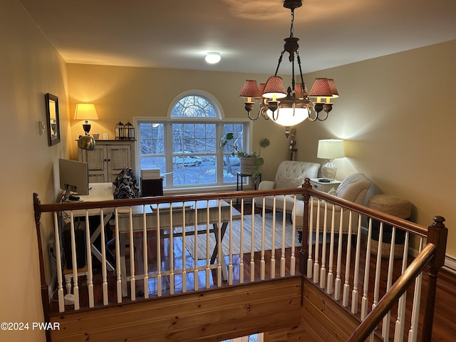 staircase featuring hardwood / wood-style flooring and a notable chandelier