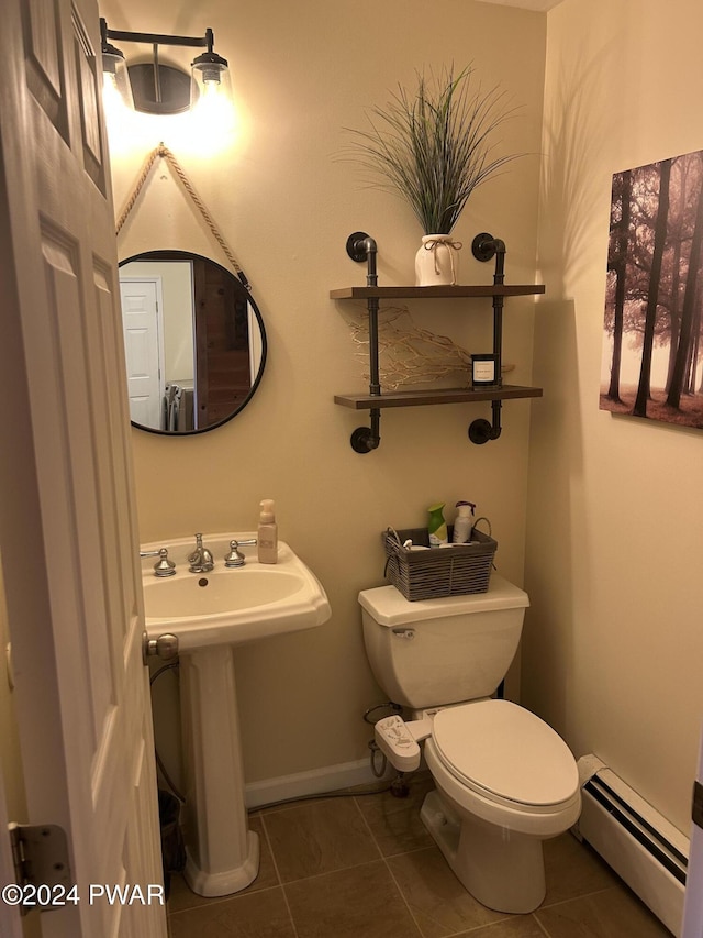 bathroom featuring baseboard heating, tile patterned floors, sink, and toilet