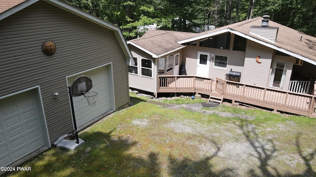 back of house featuring a garage and a deck