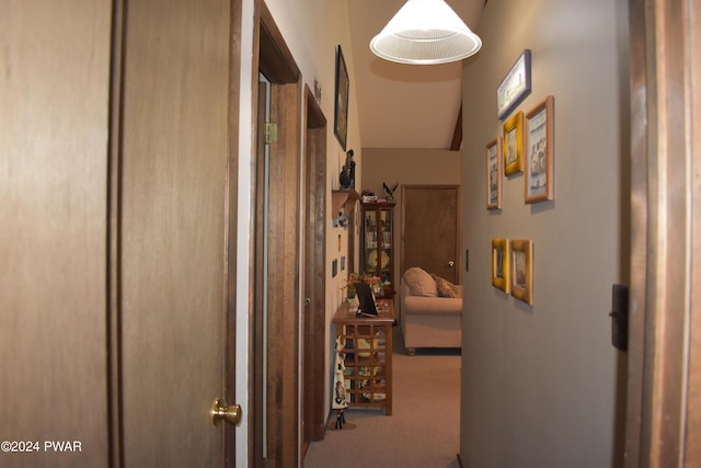 corridor with carpet flooring and vaulted ceiling