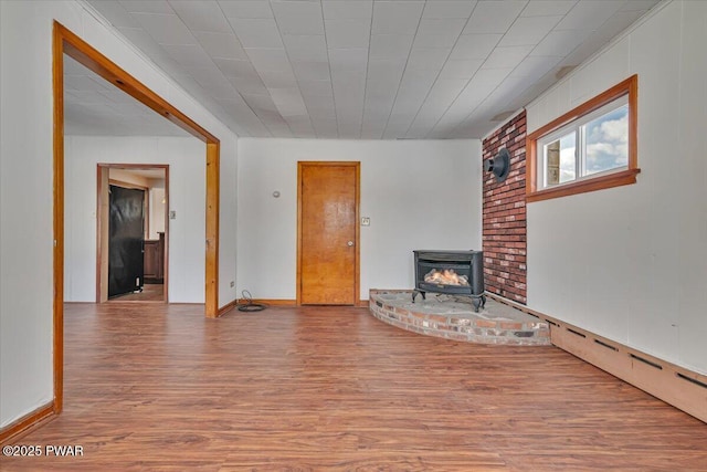 unfurnished living room featuring baseboard heating and wood finished floors