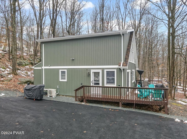 view of side of home with ac unit and a deck