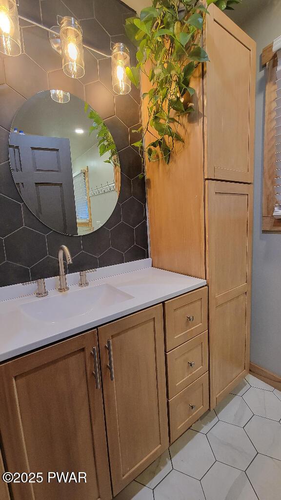 bathroom with tasteful backsplash, tile patterned flooring, and vanity