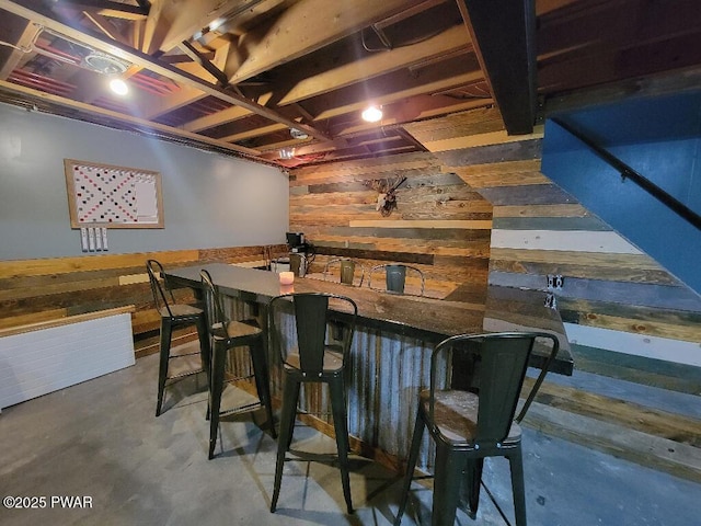 bar with concrete flooring and wooden walls